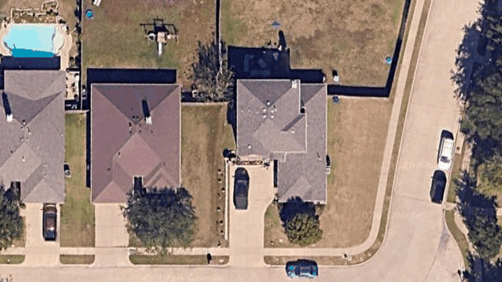 Satellite view of the Rockwall lot from above: the house, the fence lines, and the empty back lawn