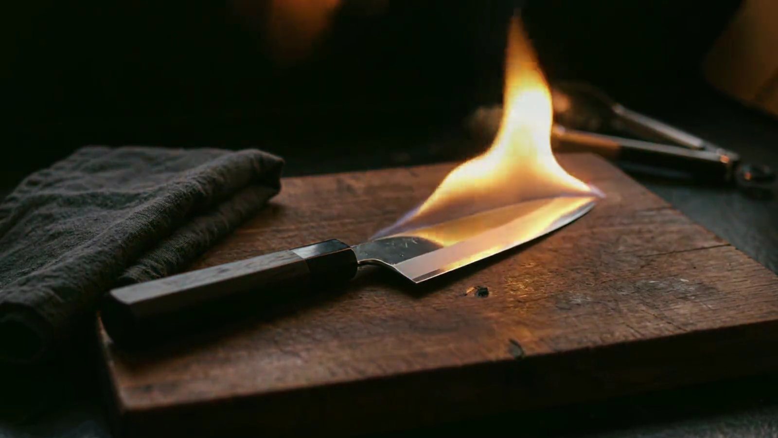 Poster frame of the Sushi On Fire craft film: the chef's knife igniting along its blade